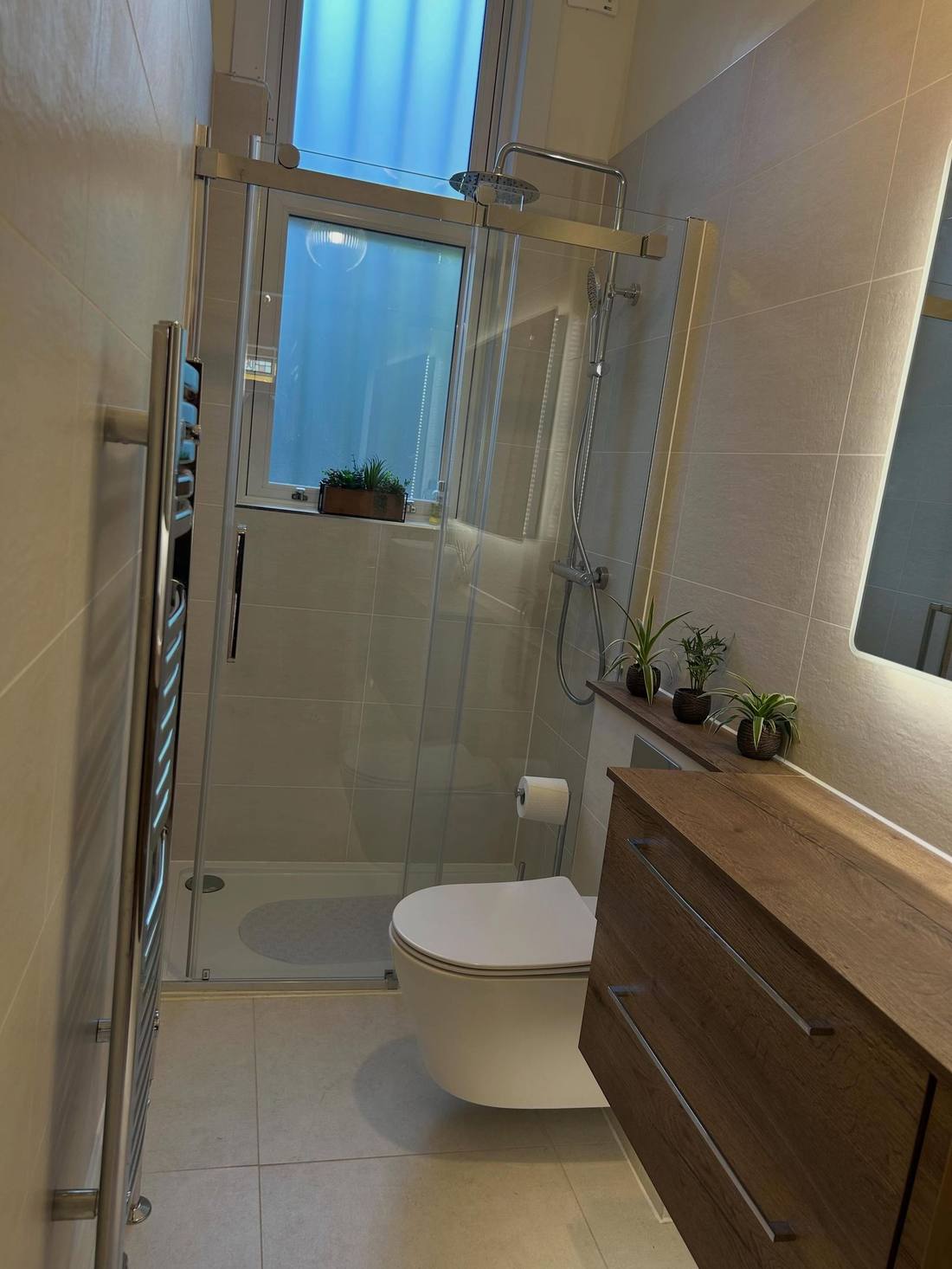 Finished walk-in shower enclosure and heated towel rail