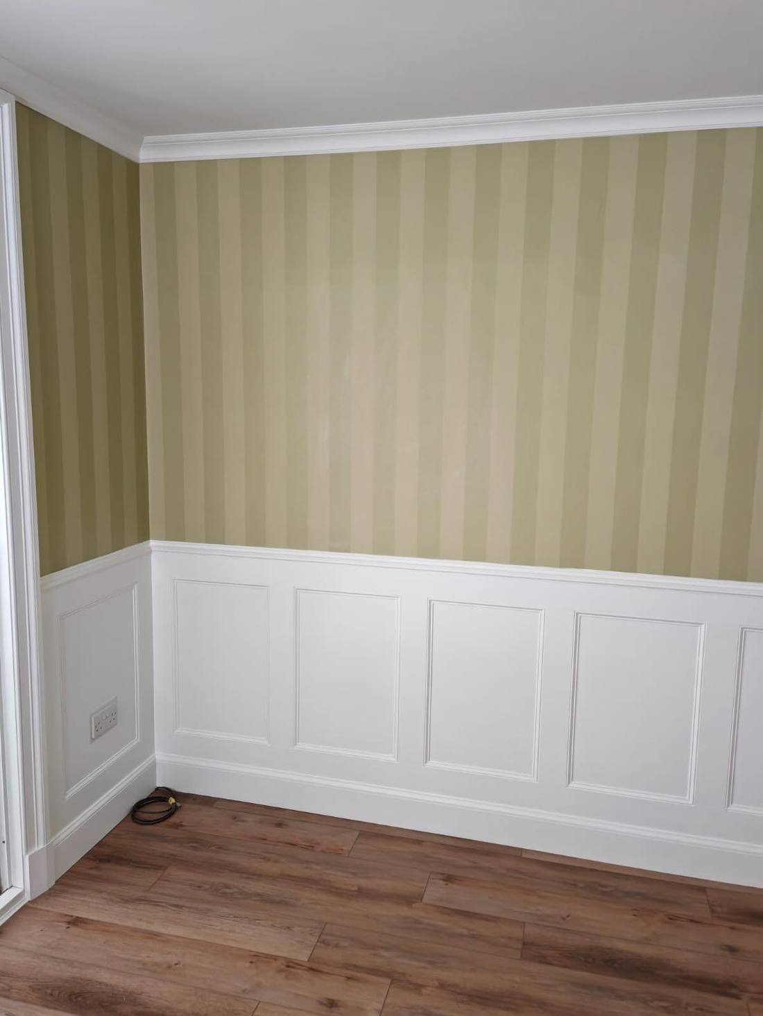 Finished dining room with white wall panelling and wood floor